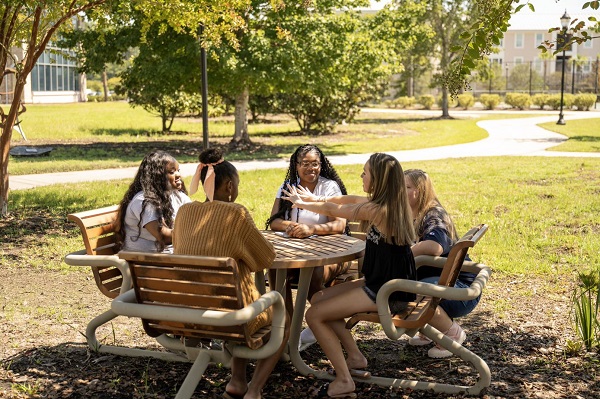 Students seated around table outside