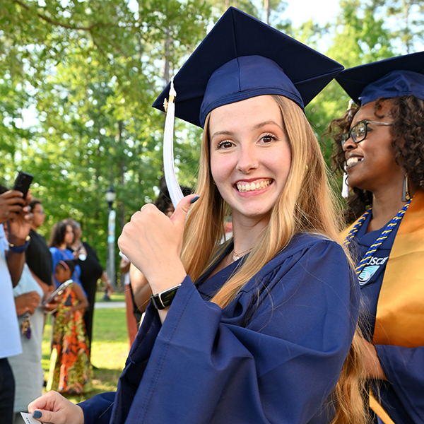Graduate giving the thumbs up sign