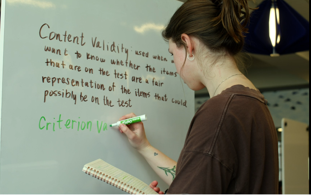 Student using a white board in the library