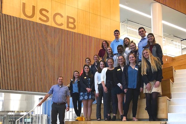 Students stand on stairs