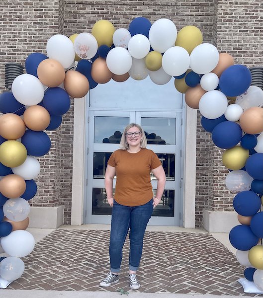 Cleo De Ridder under balloon arch at USCB