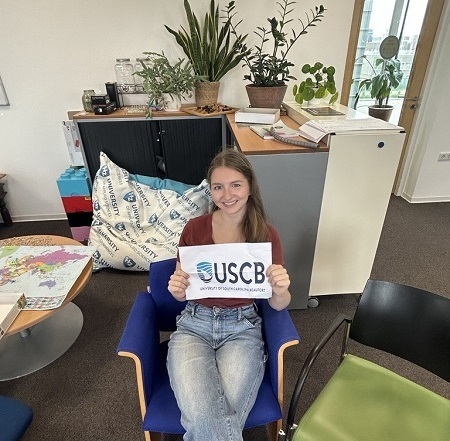 Student holding USCB sign in chair Student holding USCB sign in chair