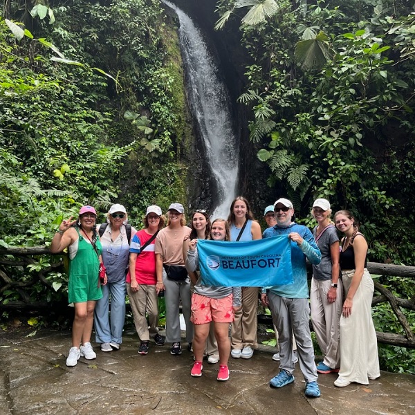 Students from USCB on a hike with a USCB flag Students from USCB on a hike with a USCB flag