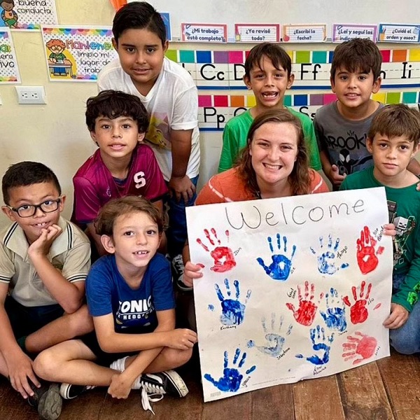 Student teacher from USCB with Costa Rica students and their handmade sign Student teacher from USCB with Costa Rica students and their handmade sign