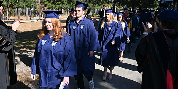 Students marching in graduation gowns