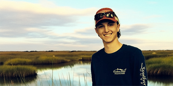 Young man beside a salt marsh Young man beside a salt marsh