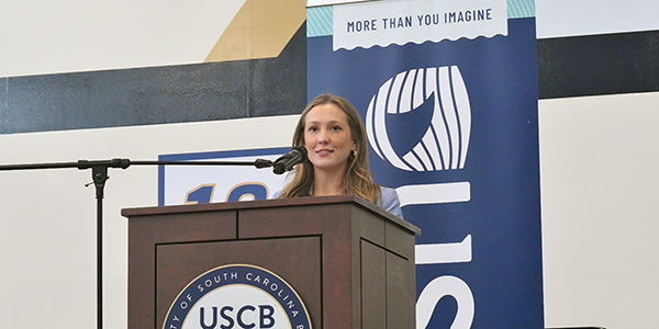 Danielle Cobb standing at a podium Young woman standing at a podium