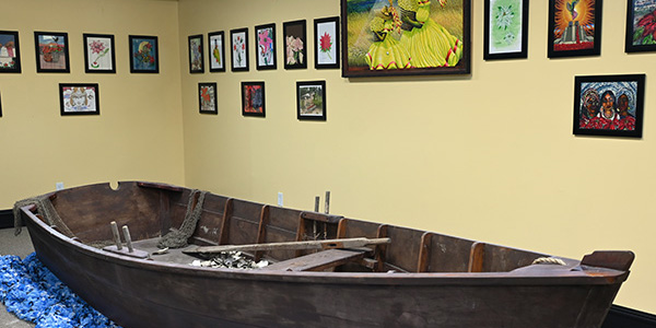 A wooden bateau exhibit and paintings
