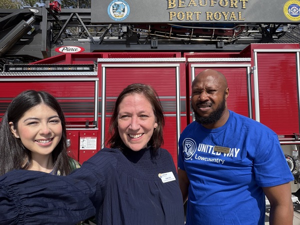 three people taking a selfie in front of firetruck