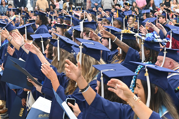 Graduates raising their hands